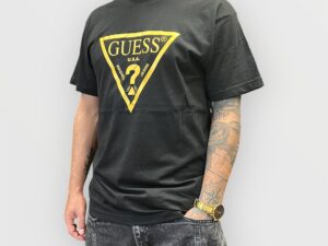 Remera Guess negra con detalles dorados para hombre, elegante y moderna.